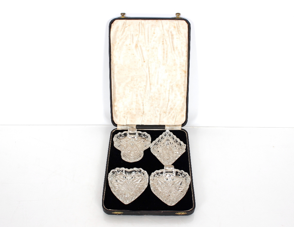 A cased set of four glass dishes in the form of card suits