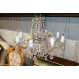A glass and gilt eight light chandelier hung with