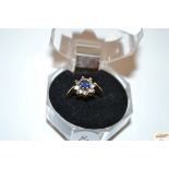 A 9ct gold ring set with central sapphire and surr