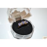 A 10k gold ring set with three amethyst interspers