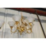 A brass and frosted glass five light chandelier