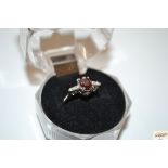 A 9ct white gold garnet and diamond ring