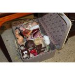 A suitcase containing various dolls, doll parts, c