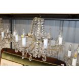 A glass and gilt eight light chandelier hung with