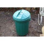 A green plastic bin; a watering can and a bucket