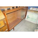 A teak side cabinet with glass sliding doors