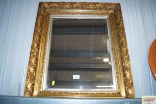 A bevel edged wall mirror contained in ornate gilt