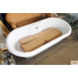 A modern roll top bath with a mixer tap, raised on