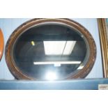 A bevel edged oval wall mirror
