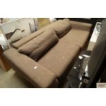 A brown upholstered three seater settee