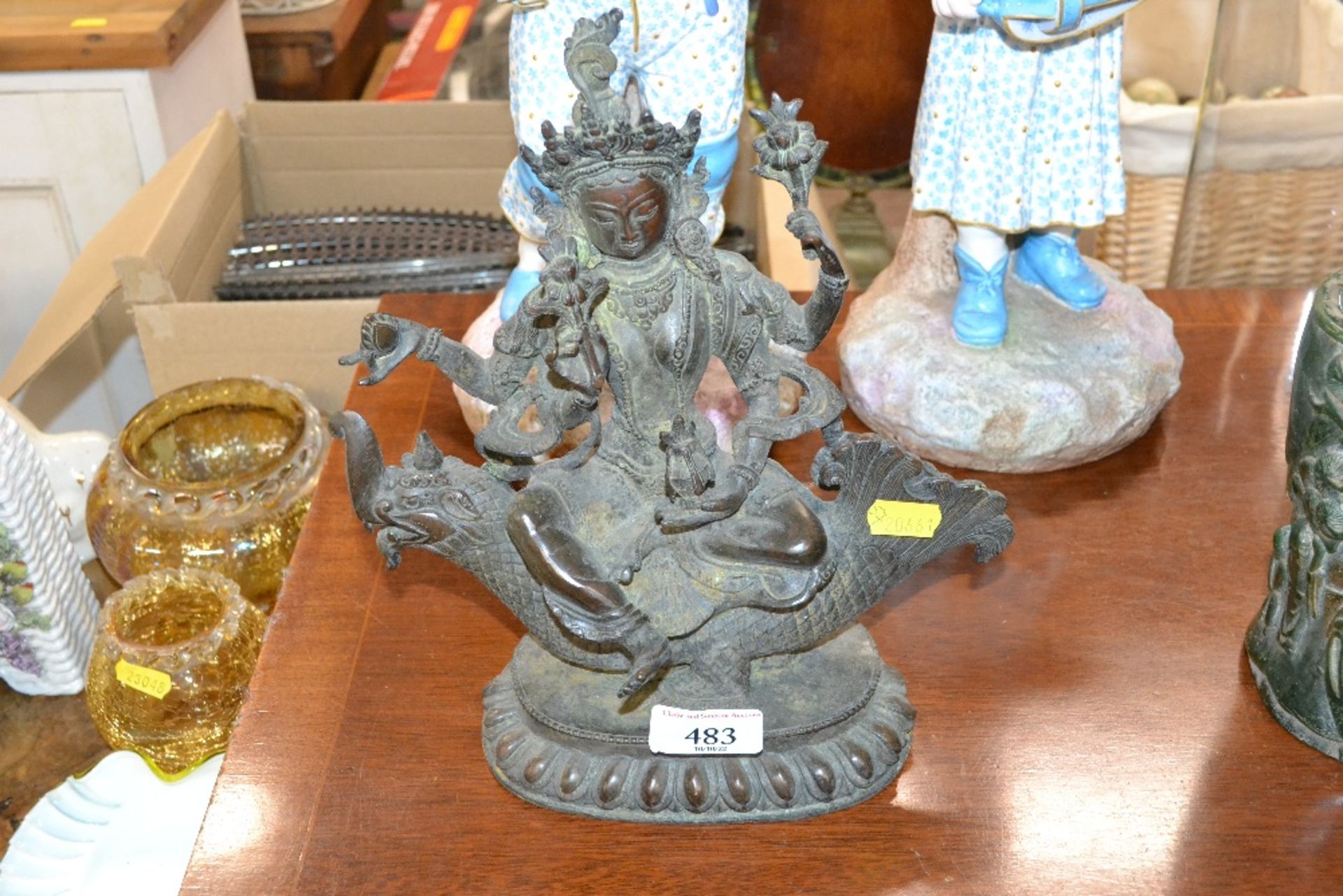 A bronzed figure of a Deity on dragon