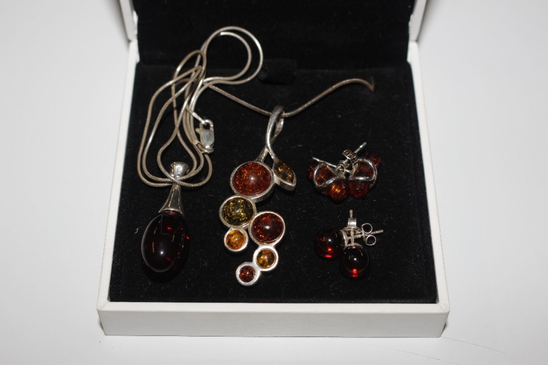 Two pairs of Sterling silver and amber pendants an