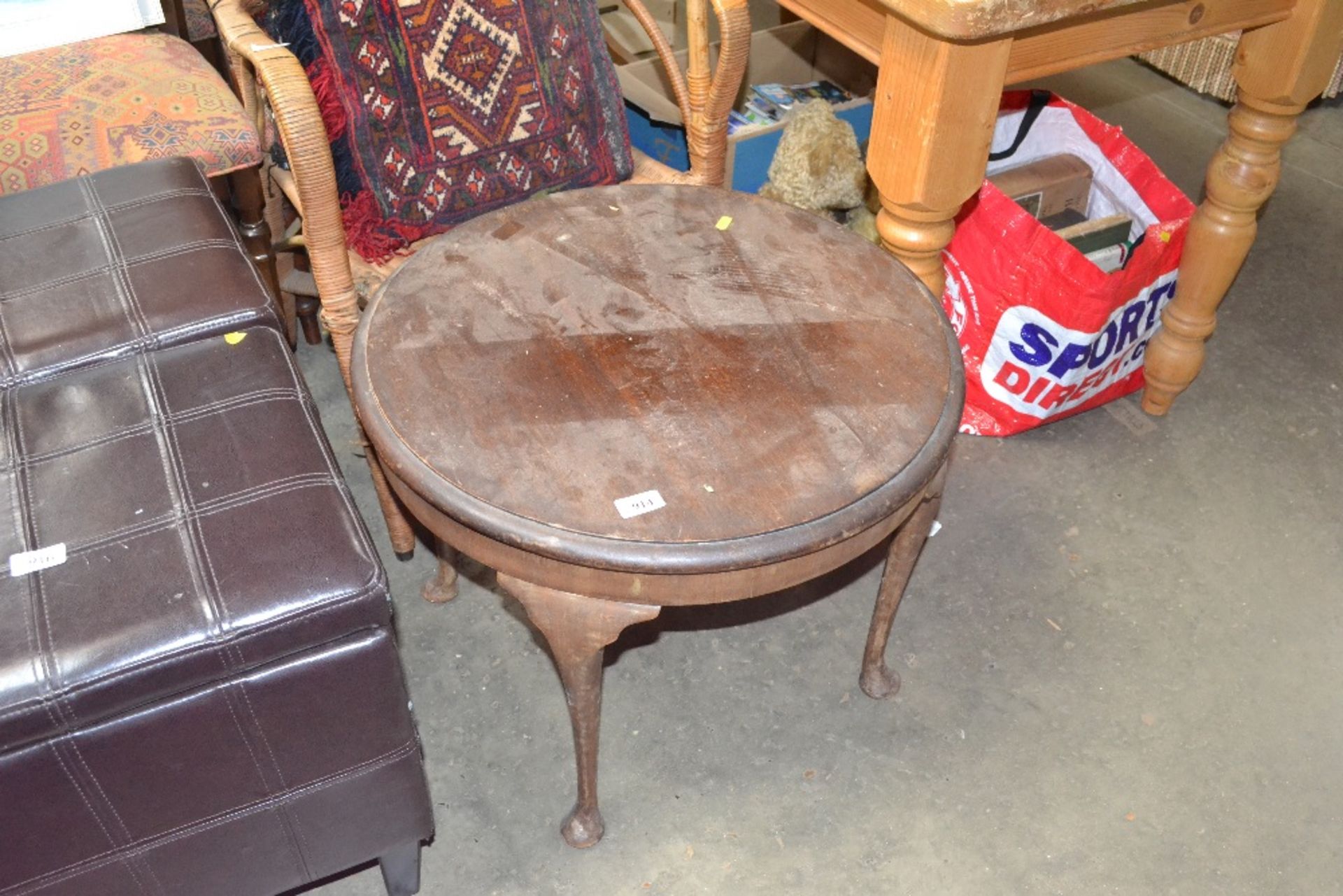 An oak circular topped table raised on cabriole su