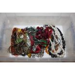 A plastic tub containing various necklaces