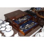 A figured mahogany cutlery canteen and contents of