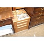 An oak effect bedside chest fitted three drawers