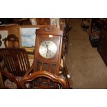 An oak cased two hole wall clock with pendulum