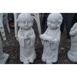 Two concrete garden ornaments in the form of child