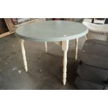 A painted circular extending dining table