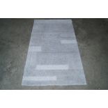 An approx. 4'9" x 2'6" grey patterned rug