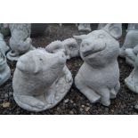 Two concrete garden ornaments in the form of pigs