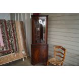 A mahogany and glazed upright corner cabinet