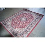 An approx. 7'7" x 7'8" red patterned rug