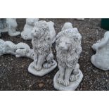 A pair of concrete garden ornaments in the form of lion