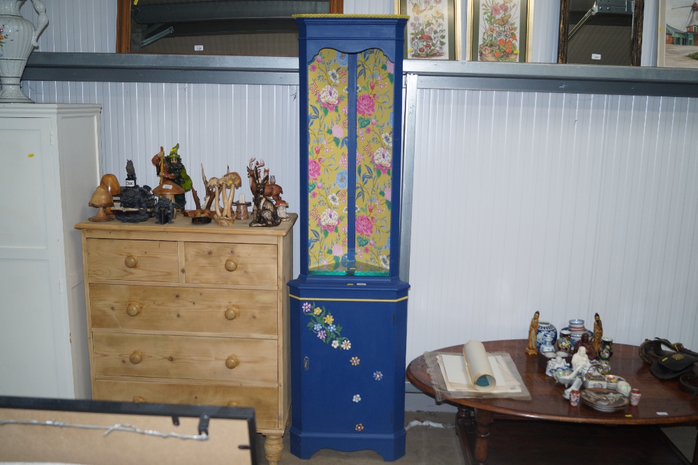 A painted and decorated upright corner cabinet