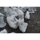 Two concrete garden ornaments in the form of Buddh