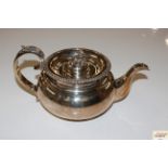 A silver teapot with floral finial, foliate decorated handle, marks indistinct, total weight 670gms