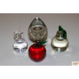 Four glass paperweights, three in the form of frui