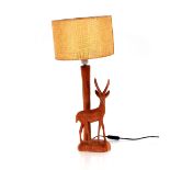A carved hardwood antelope decorated table lamp wi