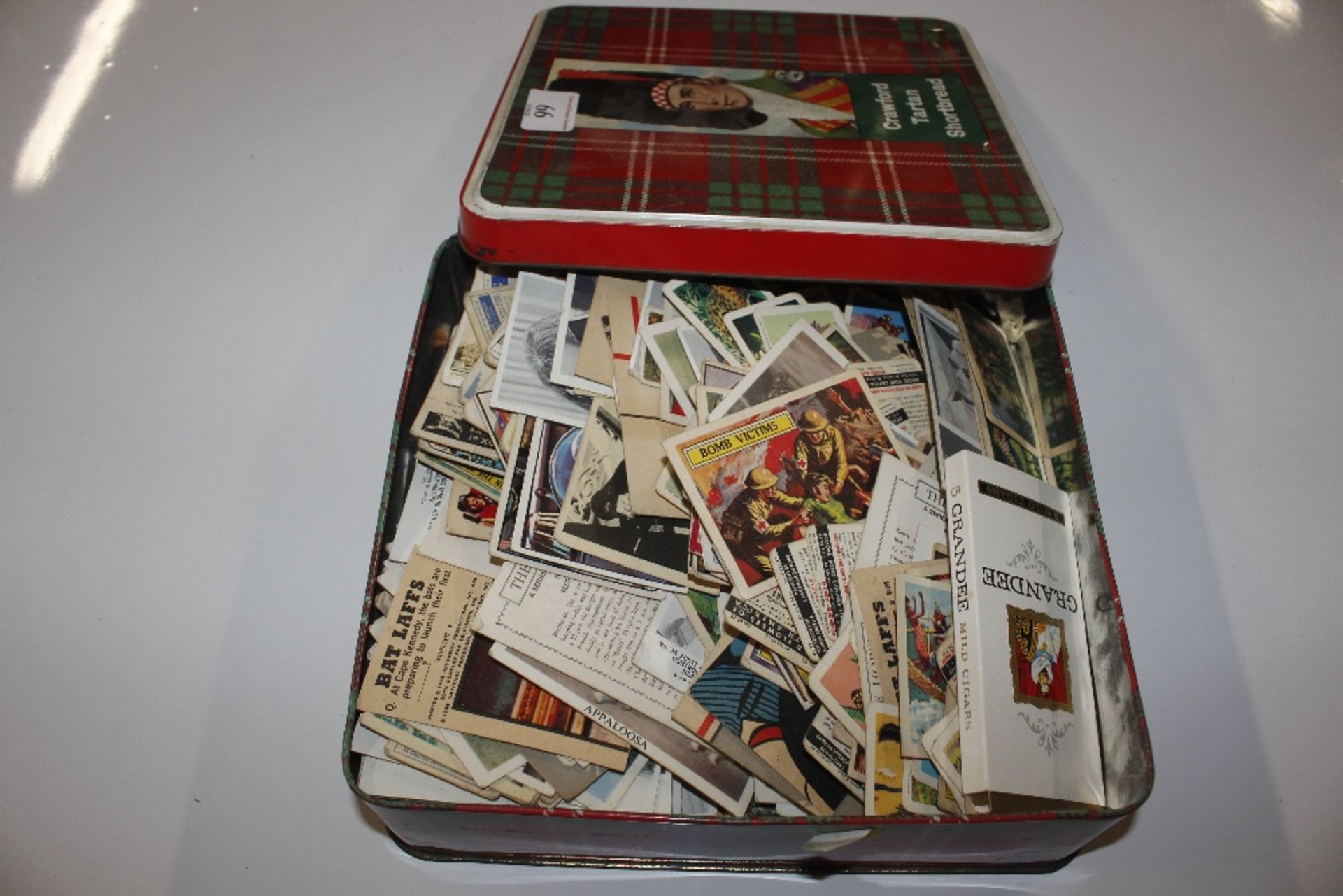 A tin containing various collector's cards