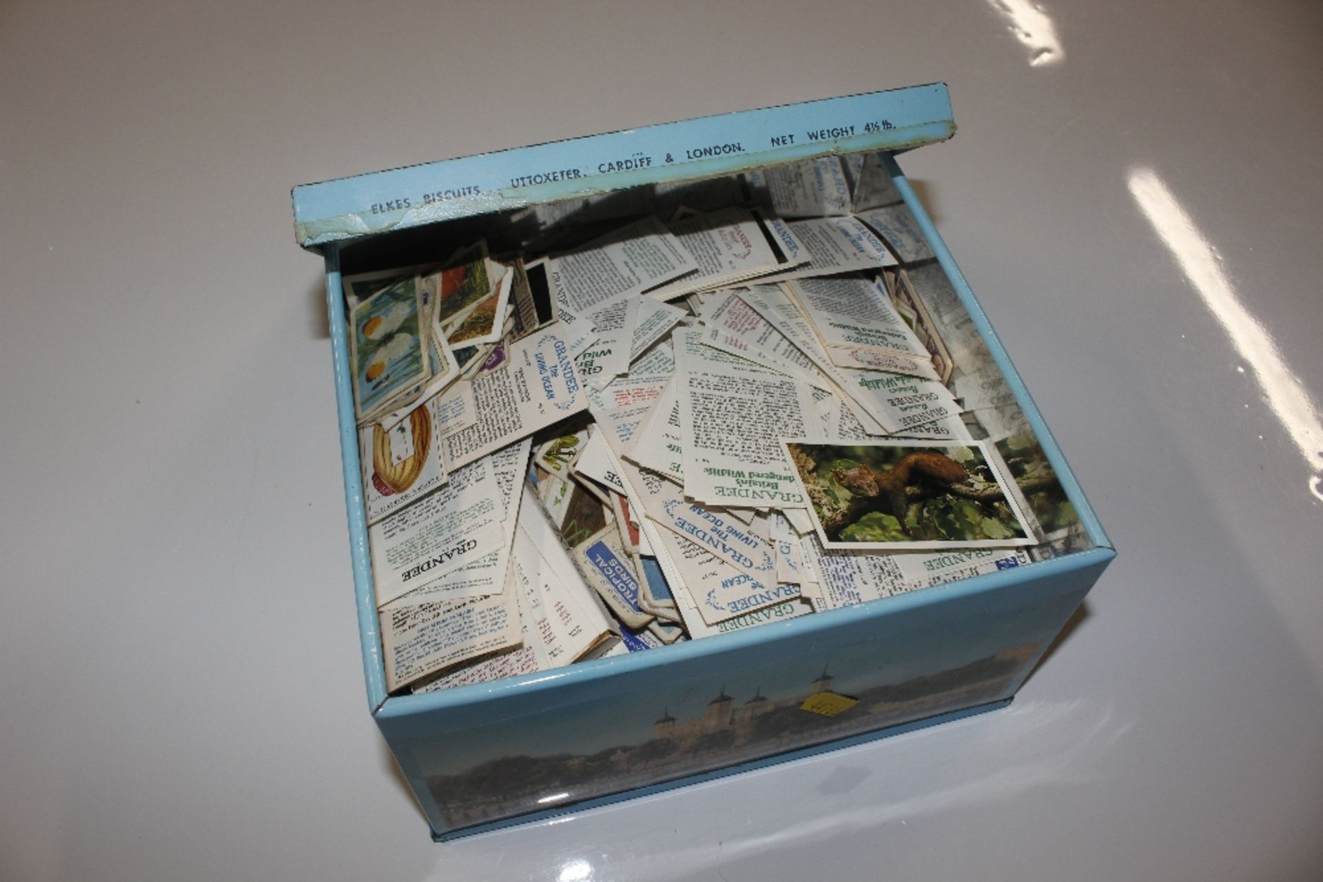 A tin containing various collector's cards