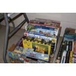 A box of various jigsaw puzzles