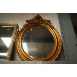 A ornate oval gilt framed bevel edge wall mirror