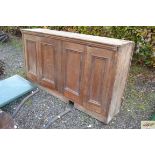 A wooden four door storage cupboard