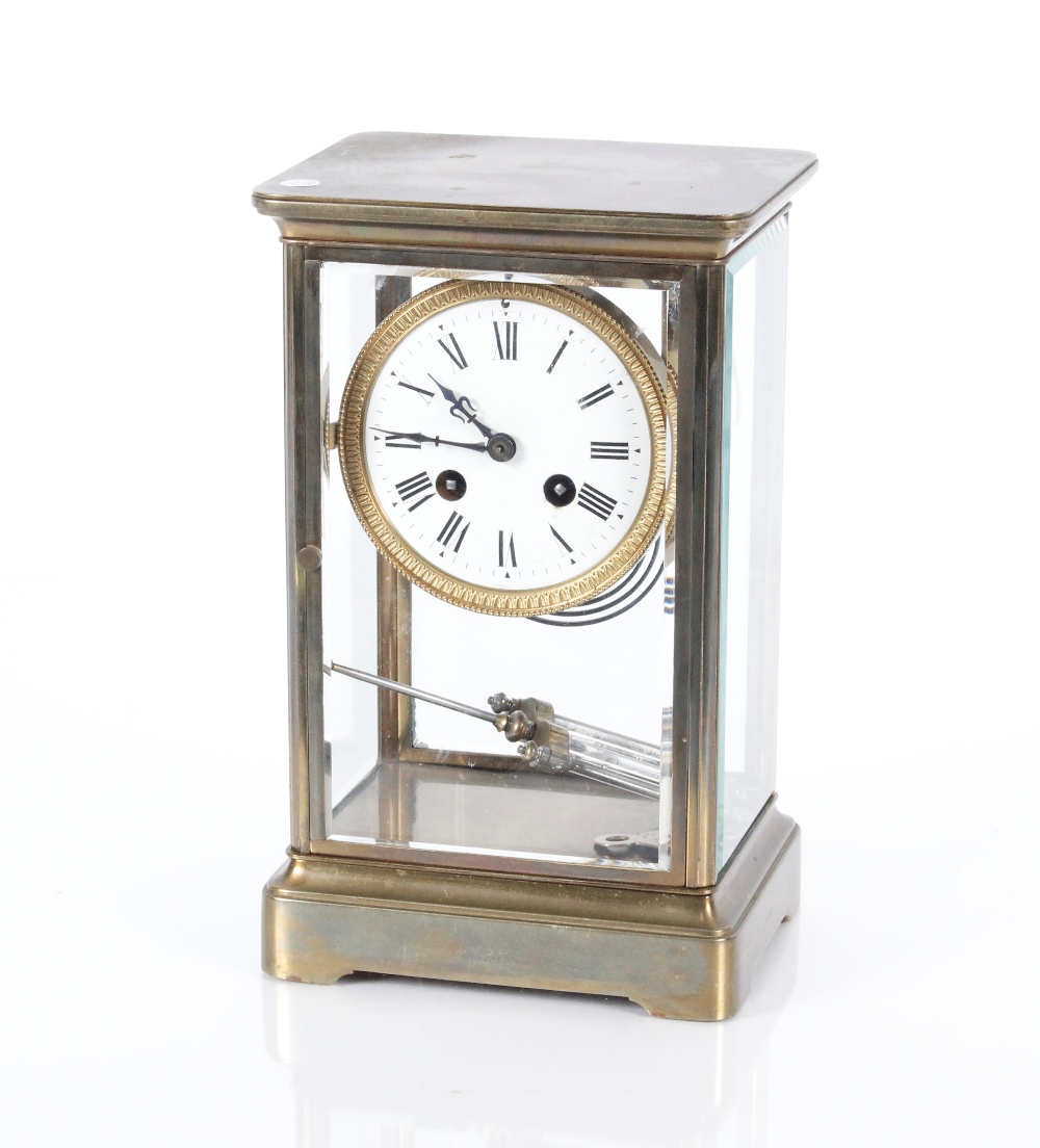 A late 19th Century brass French four glass mantel clock, the enamelled dial with Roman numerals