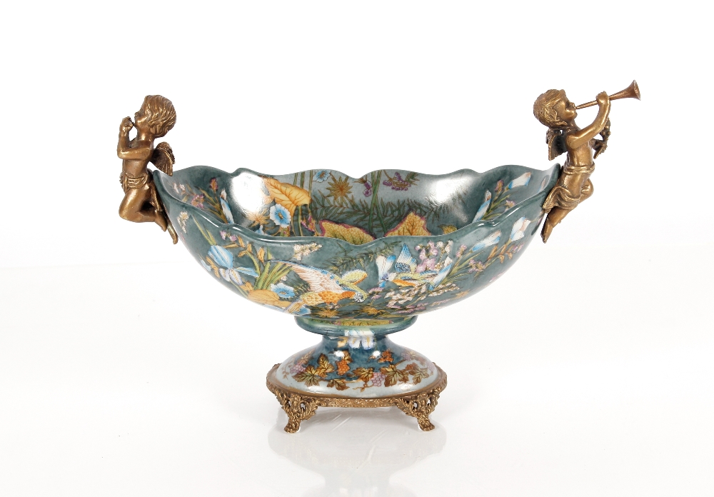 A decorative porcelain and gilt bronzed comport with cherub musician surmounts, the bowl profusely