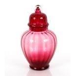 A cranberry glass pedestal vase and cover surmounted by a knop finial, 27cm, high