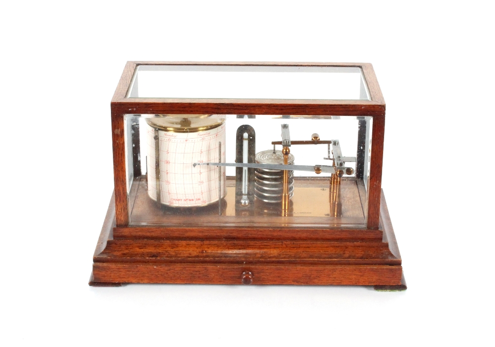 An oak cased barograph by Negretti & Zambra of London, the case with bevelled glass panels, chart