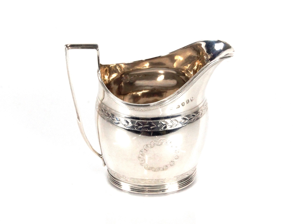 A George III silver cream jug, with foliate decoration and reeded borders, London 1800