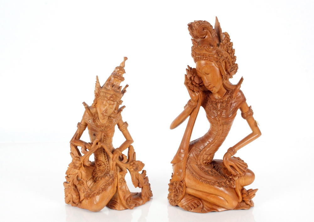 Two carved wooden Thai figures of seated maidens, 32cm x 50cm high
