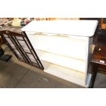 A white painted open fronted bookcase