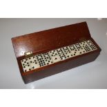A mahogany cased set of bone dominoes (one missing