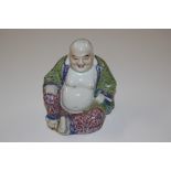 A Chinese porcelain figure of a seated Joss man de
