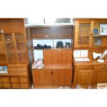 An S form teak wall unit fitted with sliding glass