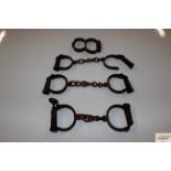 A pair of antique handcuffs and two other handcuff