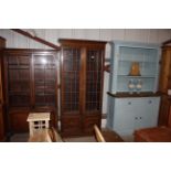 An oak and leaded glazed bookcase raised on cupboa